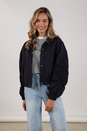 Navy blauwe Nukus Jaimy jas met capuchon en ritssluiting, ideaal voor koud weer, zichtbaar op de afbeelding.
