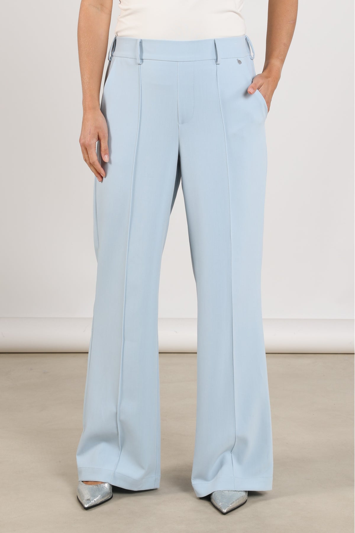 Nukus Jill Cloudy broek met rechte snit en elastische taille, lichtgrijs met subtiele textuur, gedragen door een model.
