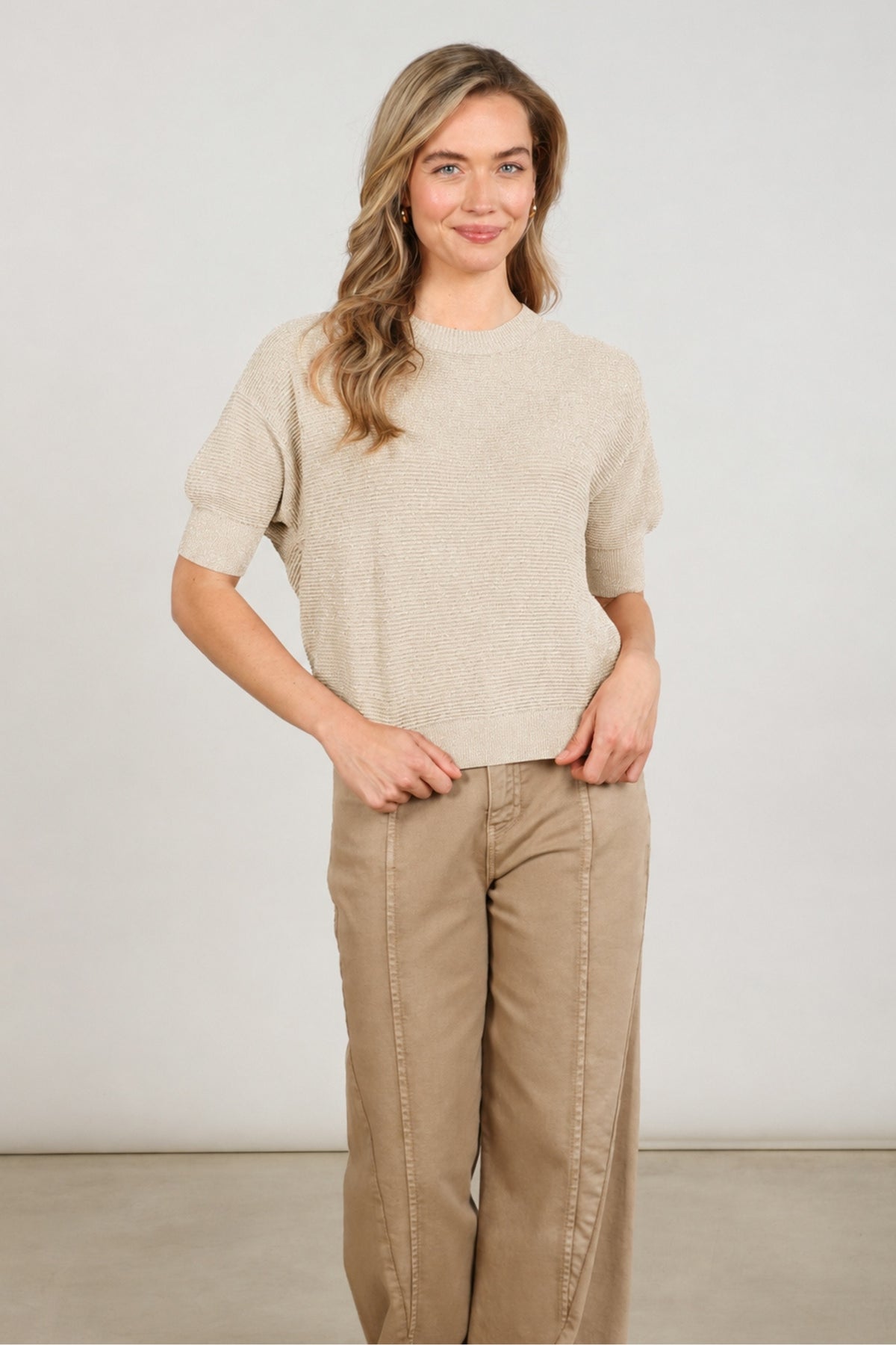 Nukus Kinty Lurex Sand top met glanzende lurex details, lichte en comfortabele damestop op een effen achtergrond