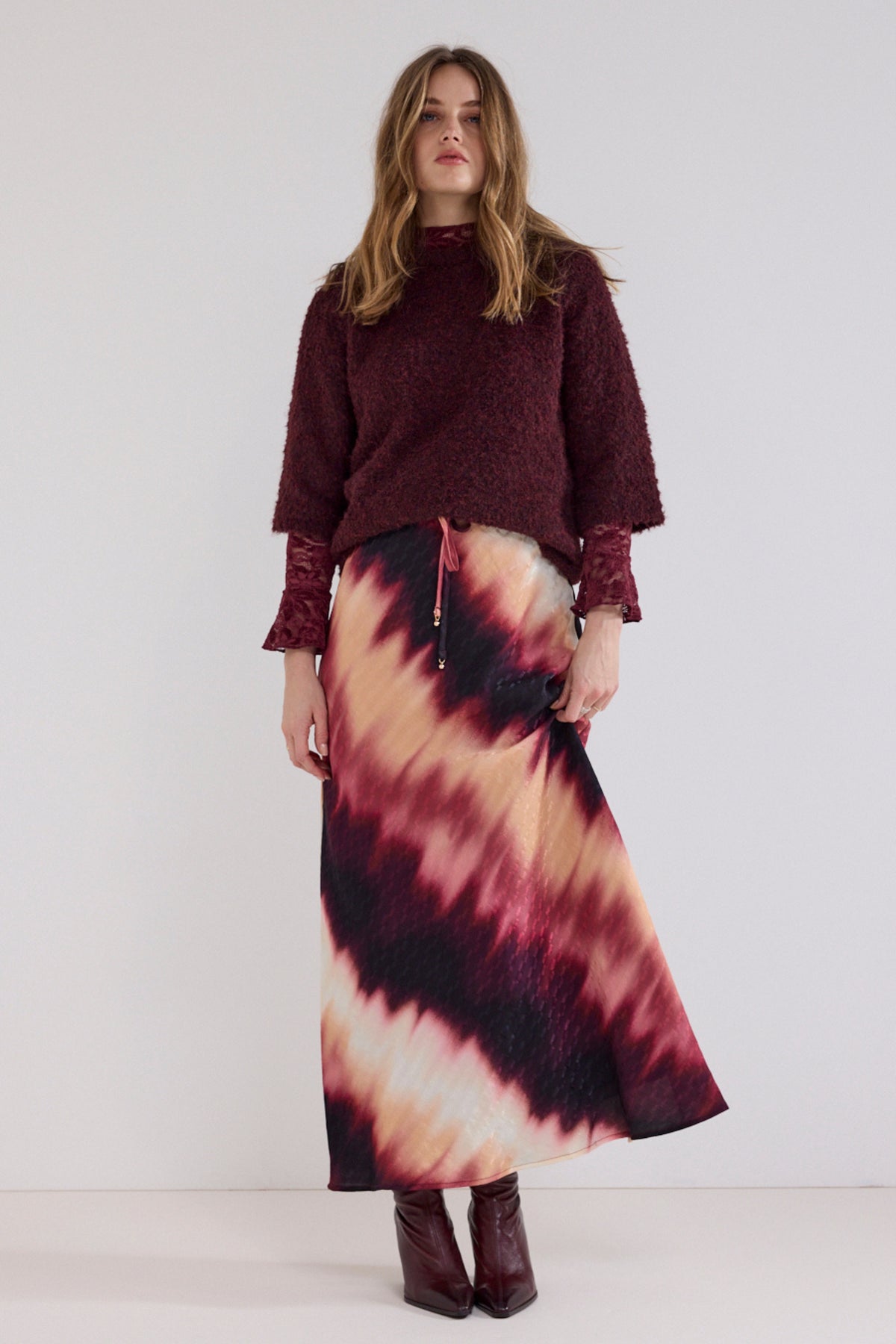 Tramontana boucle trui in Pomegranate met textuur en ronde hals, gedragen door een model.