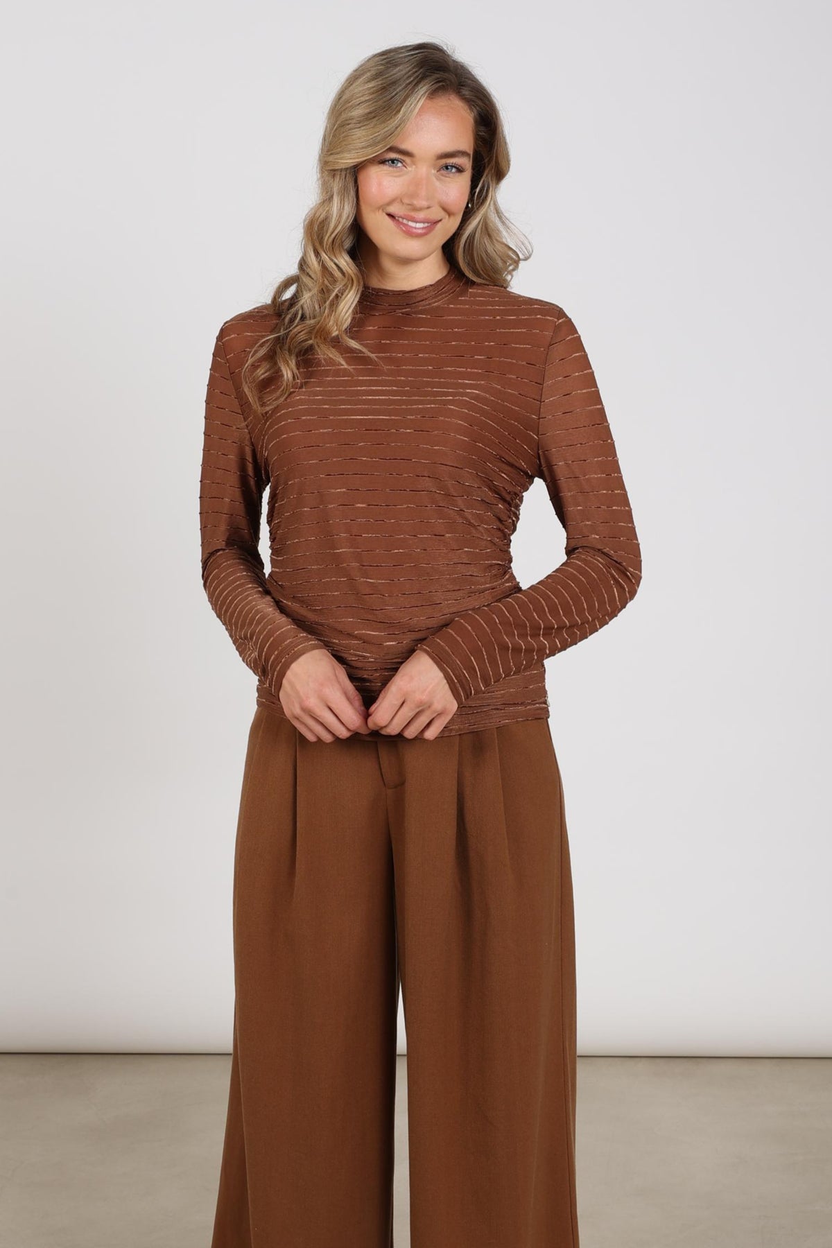 Nukus Top Gracie Stripe Espresso met zwart-witte strepen en ronde hals, gedragen door een model.