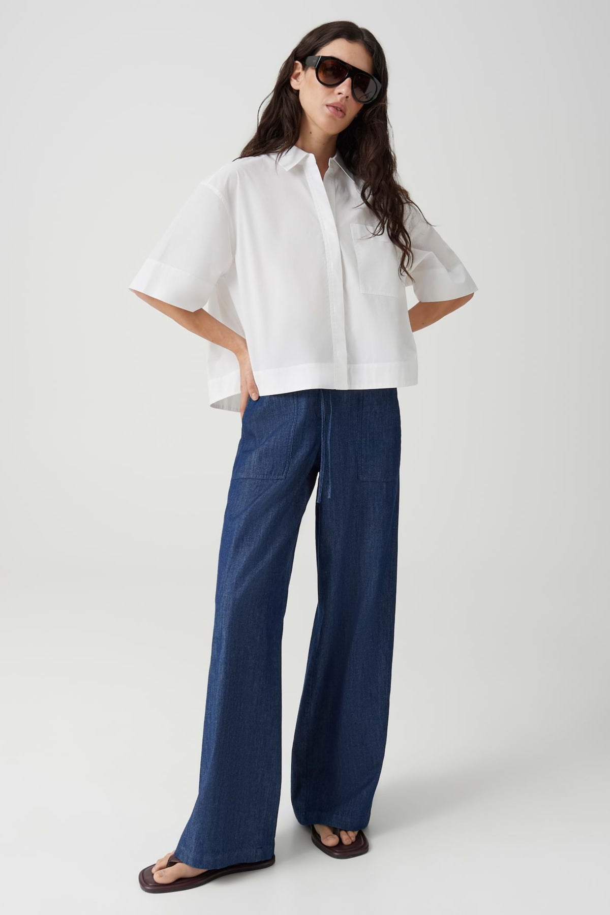 Witte blouse van Opus met lange mouwen en knoopsluiting, gedragen door een model, op een neutrale achtergrond.