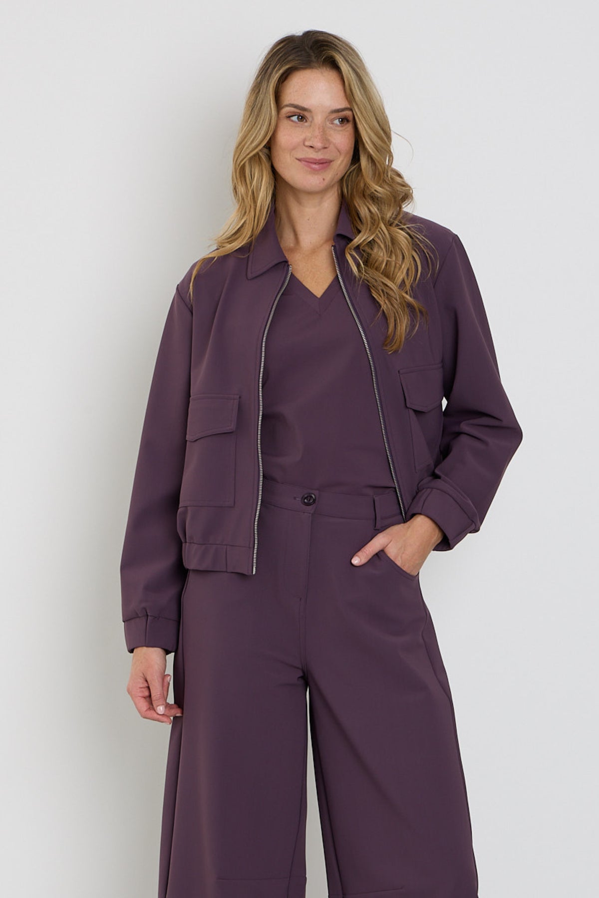 Mi Piace Bonded Travel Jacket Balloon Plum, een gewatteerde reisjas met een bloemrijke print en comfortabele pasvorm.