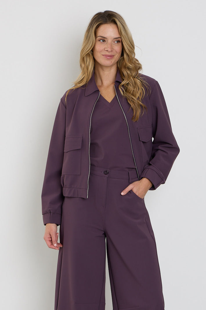 Mi Piace Bonded Travel Jacket Balloon Plum, een gewatteerde reisjas met een bloemrijke print en comfortabele pasvorm.