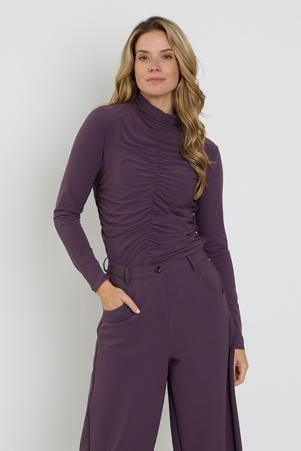Mi Piace Travel Top Wrinckle Light Plum, lichtpaarse blouse met rimpelpatroon, getoond op een model.