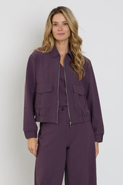 Mi Piace Travel Top Plum Perfect 202271, donkerpaarse reisblouse met korte mouwen en elegante snit, hangend op een kleerhanger.