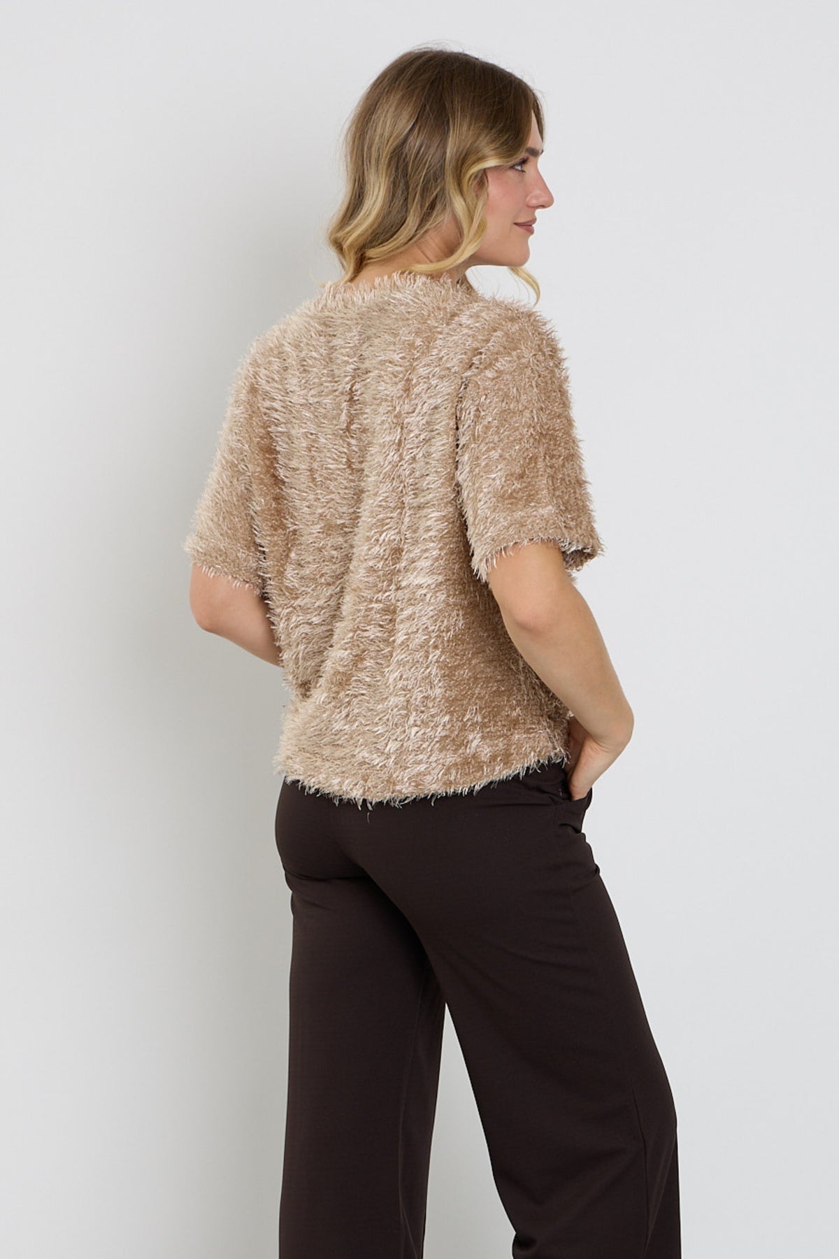Lichte en zachte Enjoy Fluffy Taupe top met ronde hals, gedragen door een model, close-up van de textuur en kleur.