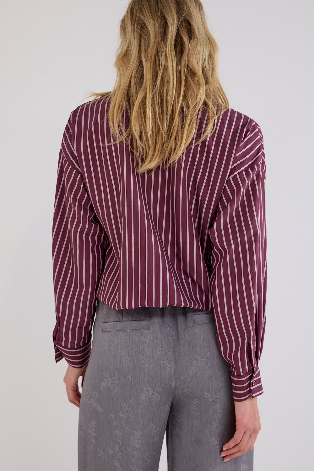 Blouse van Tramontana met strikapplicatie en granaatkleurig ontwerp, elegante damesblouse met modieuze details.