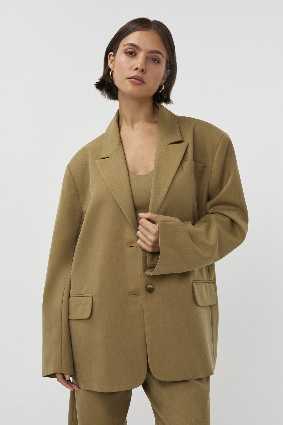 Groene blazer van Studio Amaya, model Campello, getoond op een persoon in een modieuze setting