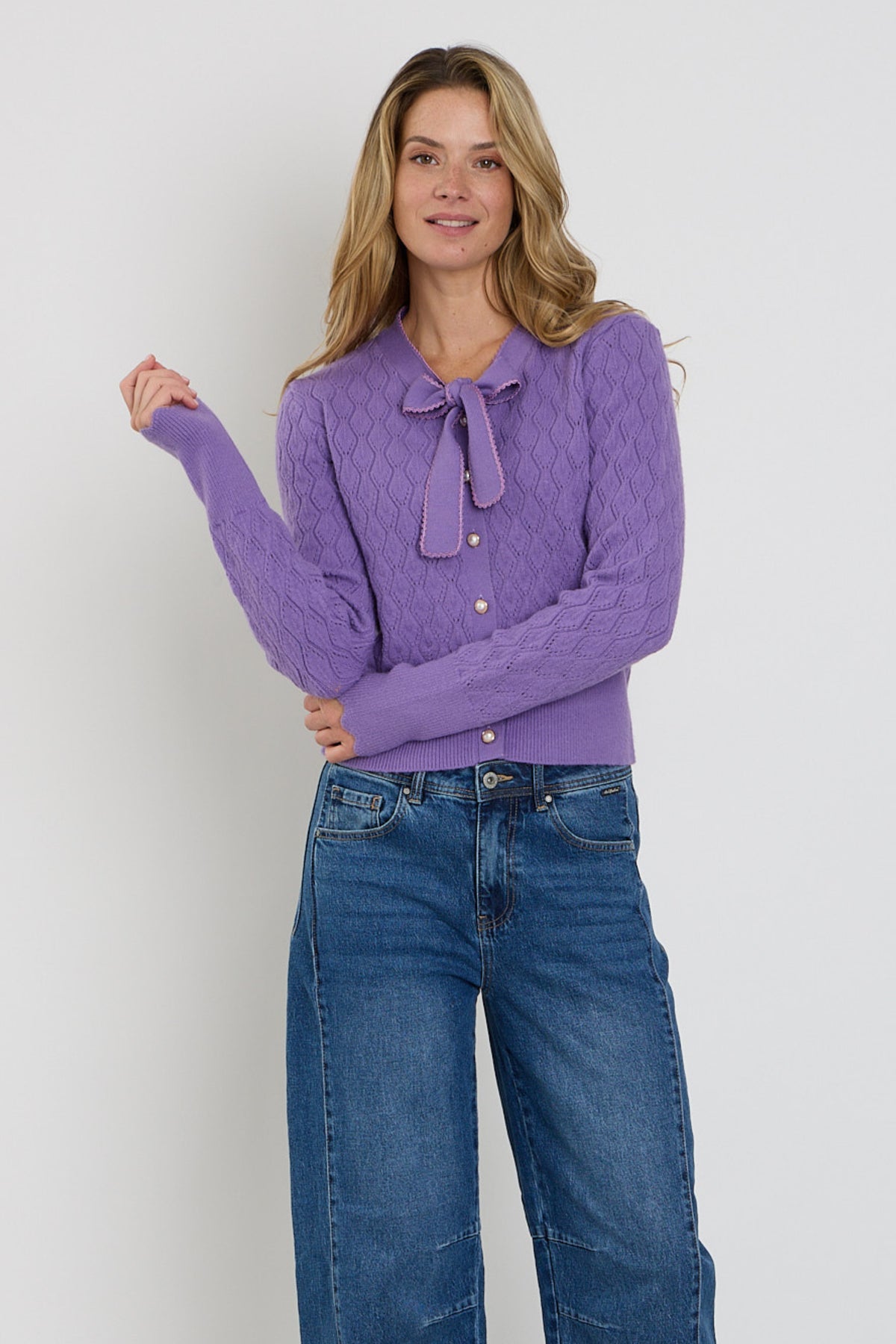 Lichte blauwe Ajour Bow vest van Mi Piace met decoratieve knoopsluiting en gebreide textuur, zichtbaar in de afbeelding.