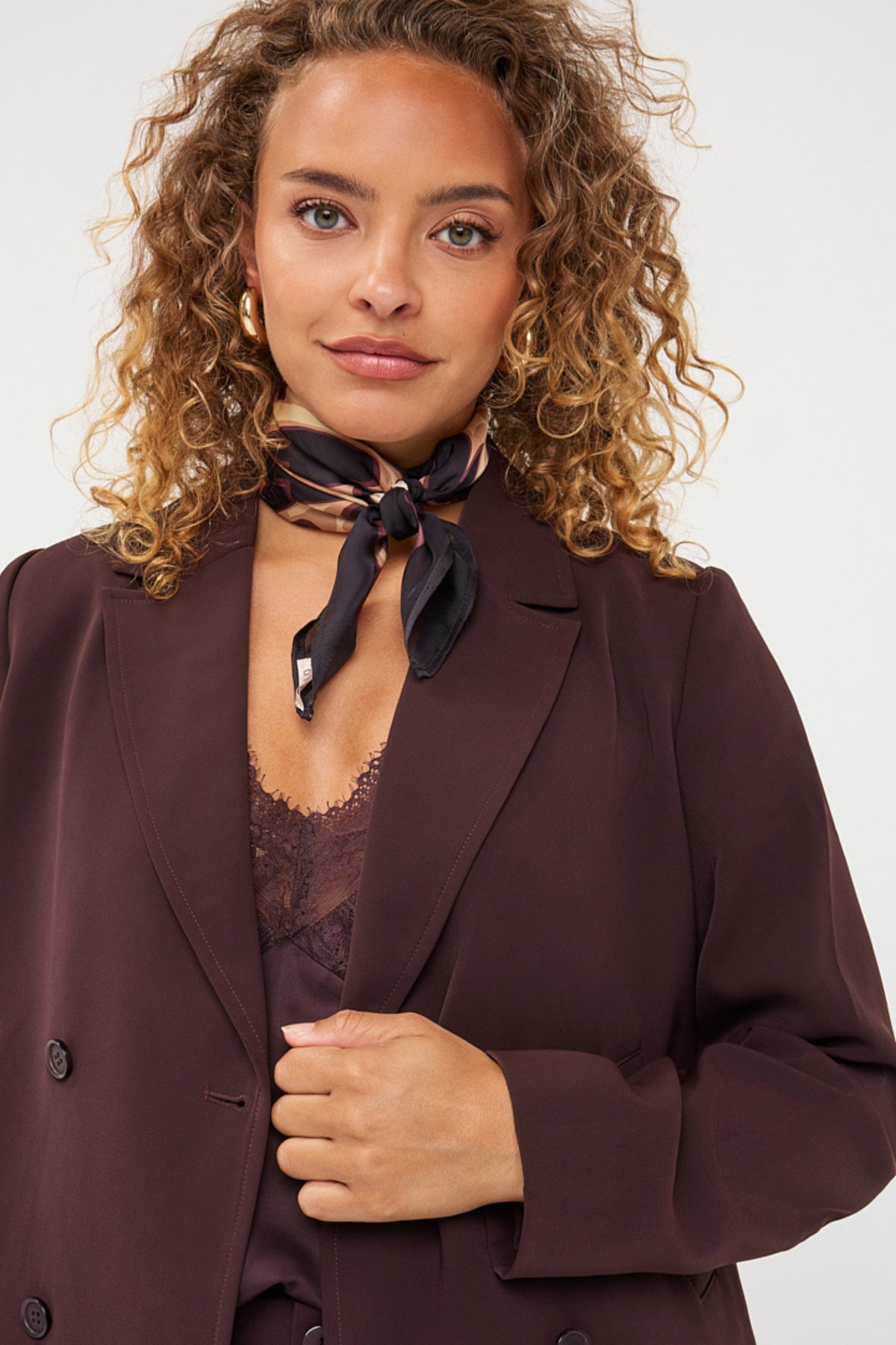 Cacao gekleurde cropped blazer van EsQualo, getailleerd model met knopen en revers, gedragen door een model.