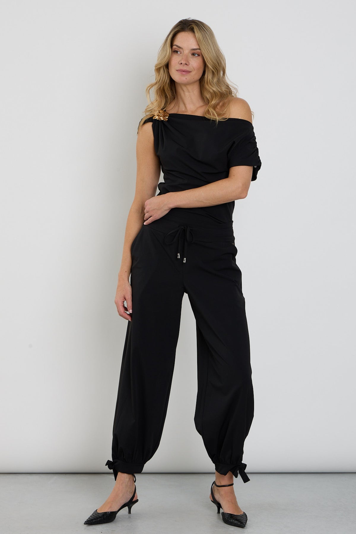 Zwarte Mi Piace Travel Balloon Bottom Bow broek met wijde pasvorm en strikdetail, zichtbaar vanaf de voorkant.