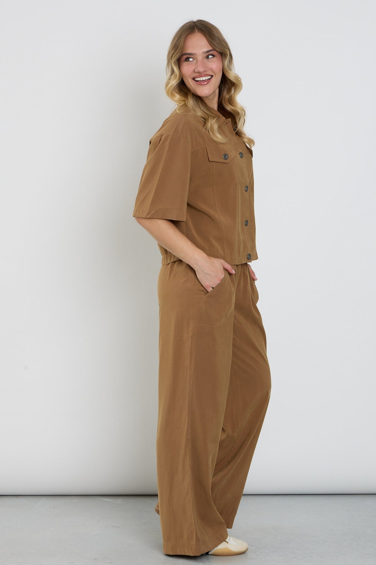 Lange brede broek van Enjoy in camel kleur, losvallend model met wijde pijpen en tailleband, geschikt voor casual en elegante outfits.