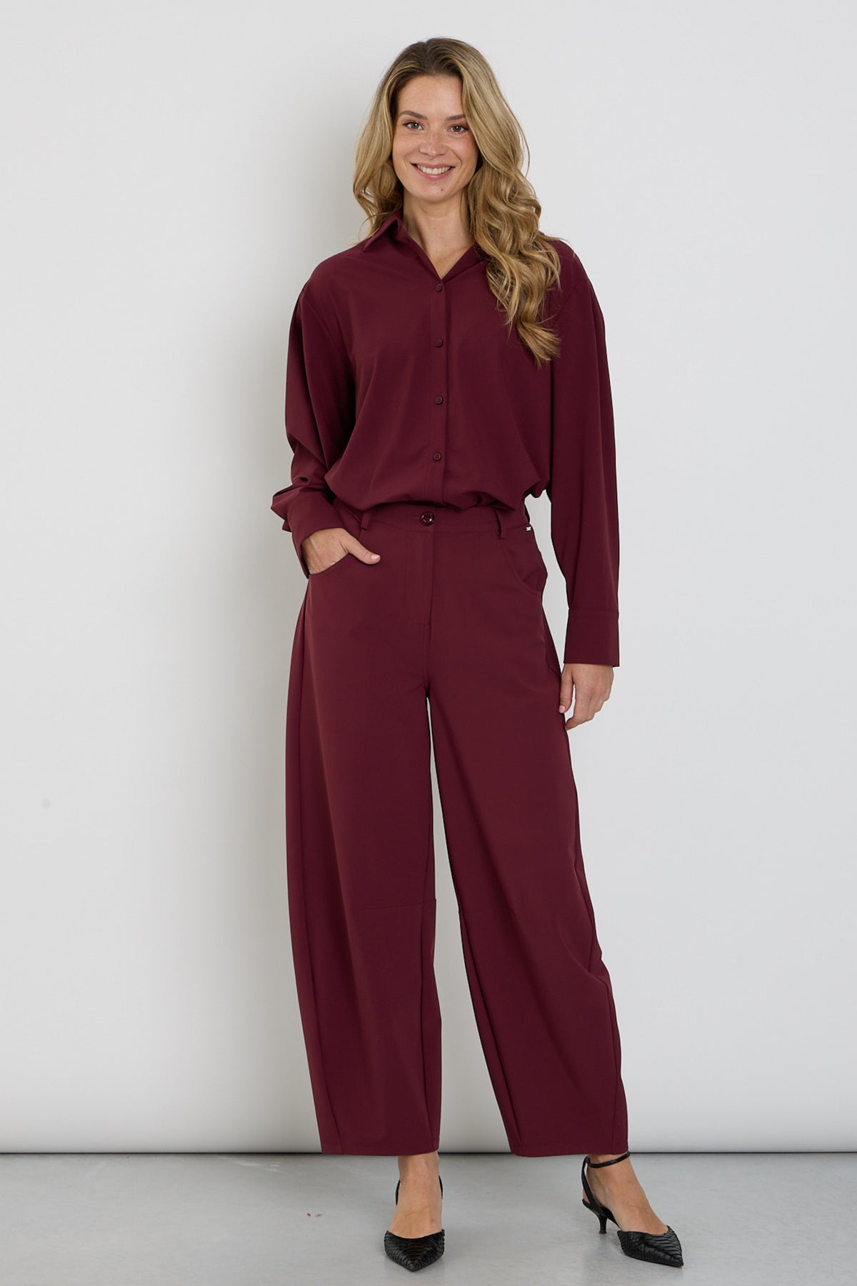 Bonded travel broek van Mi Piace in burgundy, met comfortabele pasvorm en praktische details, zichtbaar in de afbeelding.