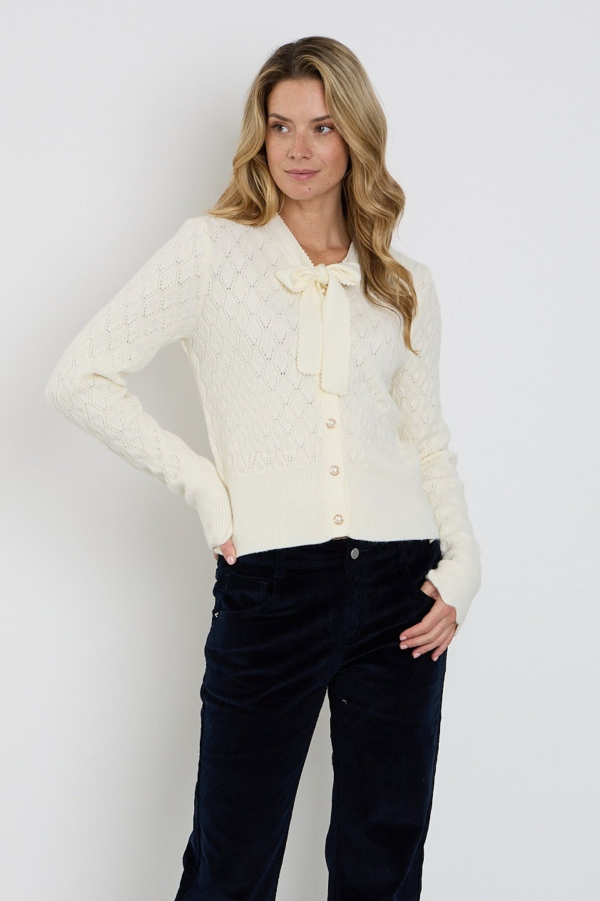 Offwhite Mi Piace vest met ajour patroon en strikdetail, elegante en lichte damesvest voor elke gelegenheid.