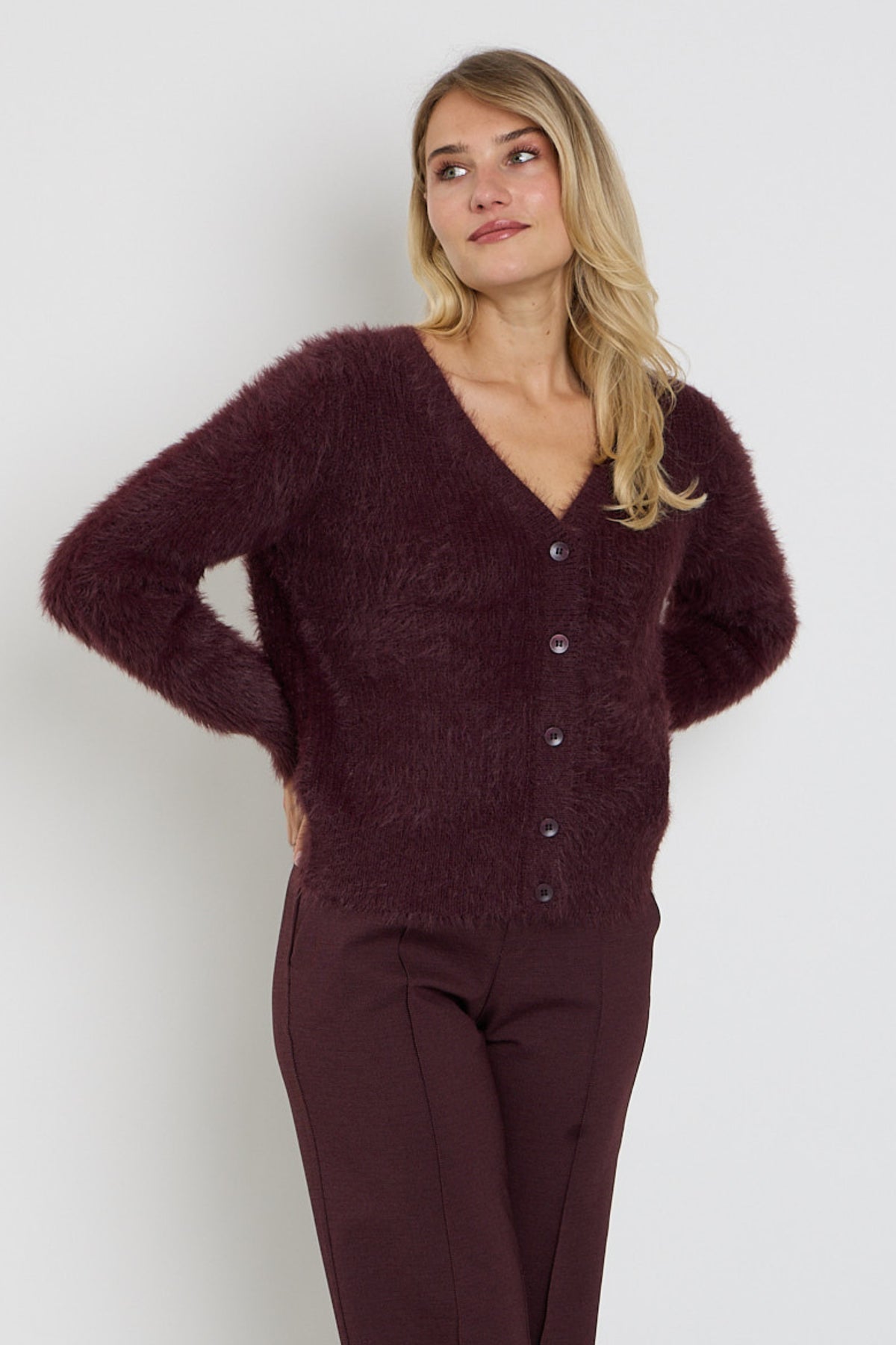 Donkere bordeaux fuzzy vest van Red Button met zachte textuur en knopen, gedragen door een model.
