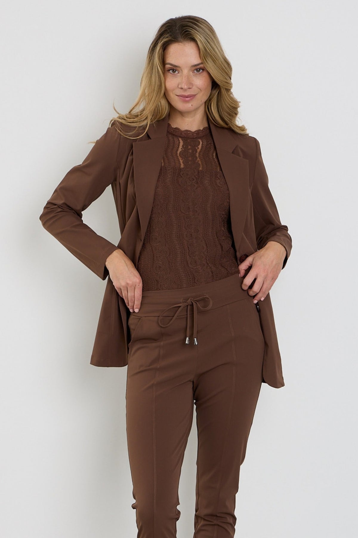 Mi Piace reisblazer in chestnut kleur, close-up van het stijlvolle, gebreide ontwerp en de details van de jas.