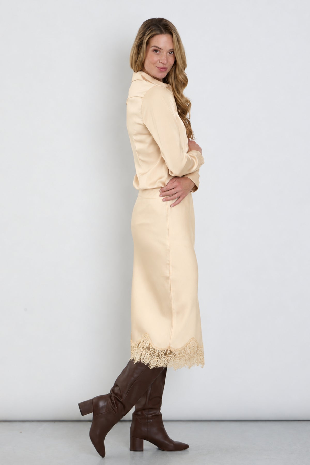 Zwarte satijnen rok met kanten details van Mi Piace, elegante sandalen en een zijden top voor een chique uitstraling.