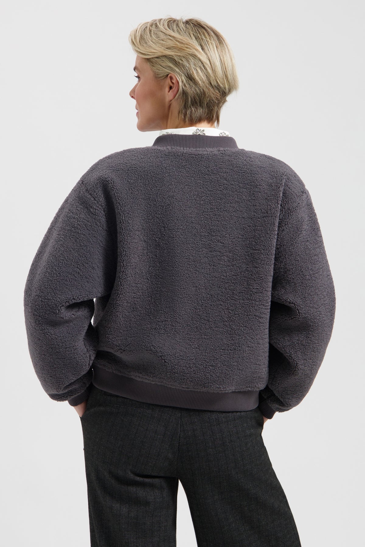 Grijze Lady Day Lincy jas met capuchon en elastische taille, gedragen door model op straat.