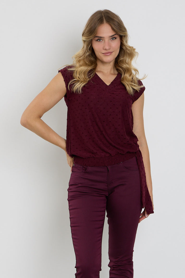 Enjoy blouse met strik en structuur in portkleur, close-up van de textured stof en elegante details.