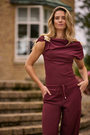 Mi Piace Travel Top Broche in burgundy, close-up van de elegante sieradenbroche met luxe details.