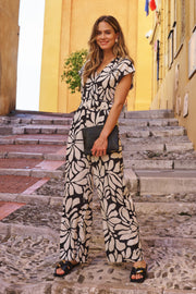 EsQualo jumpsuit Sunset Print HS26.28209 met kleurrijk zonsondergang patroon en wijde pijpen, gedragen door een model.