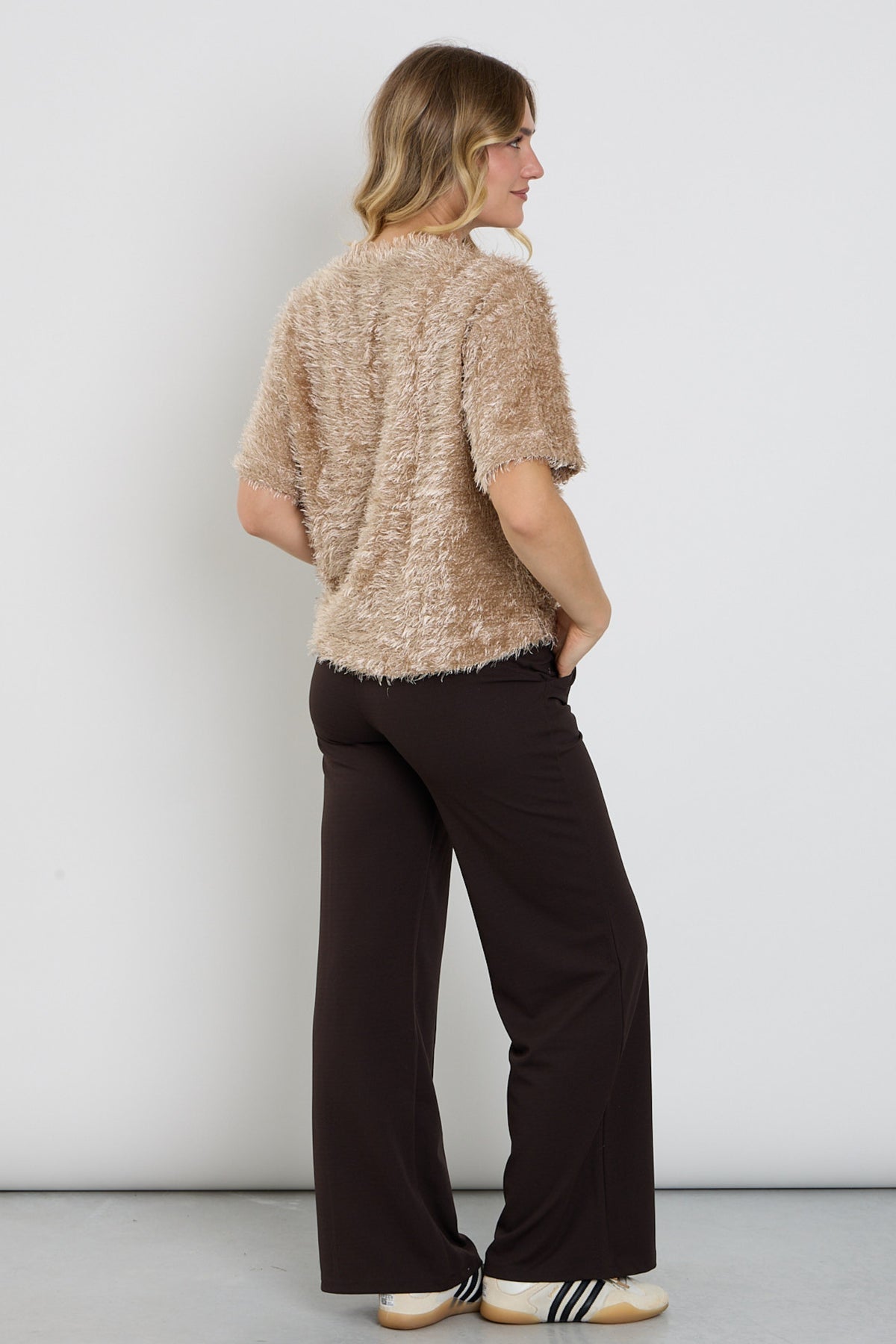 Breed uitlopende bruine broek van Enjoy met wijde pijpen en elastische taille, gedragen door een model in een neutrale setting.