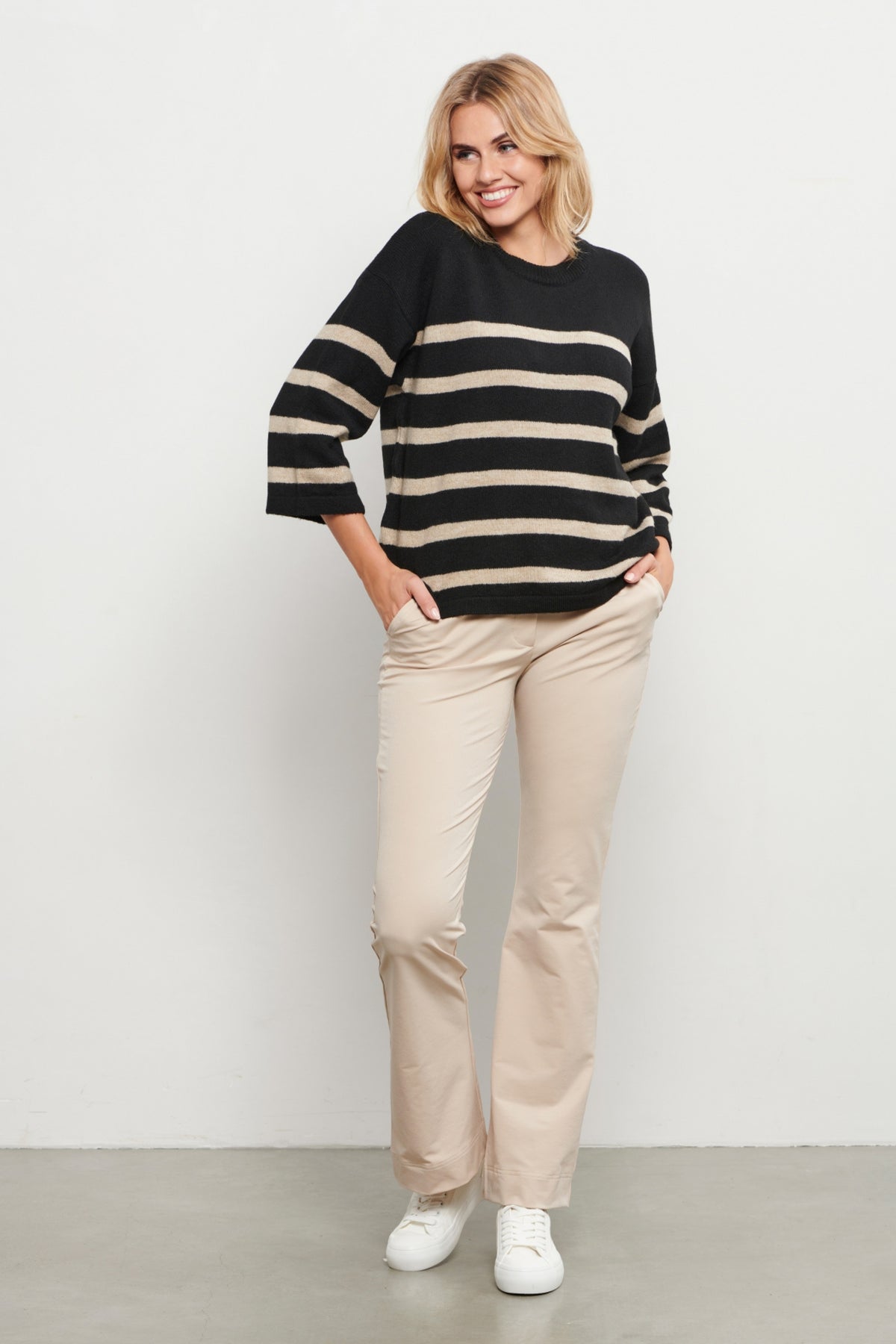 Lichte travel broek Penelope Flare van &Co woman, zandkleurig met wijde pijpen en comfortabele pasvorm.