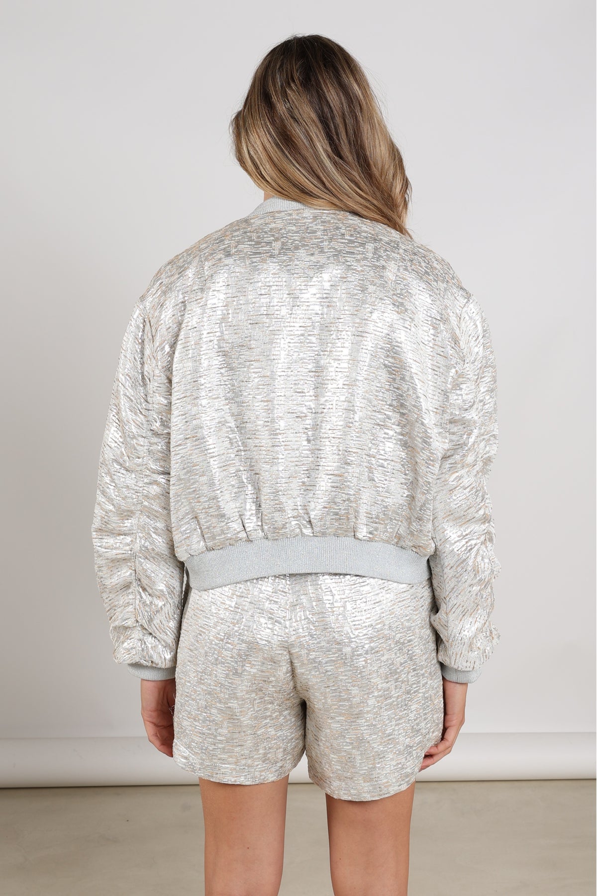 Nukus Babette Silver Camel winterjas met glanzende afwerking en capuchon, geschikt voor dames in een neutrale kleur.