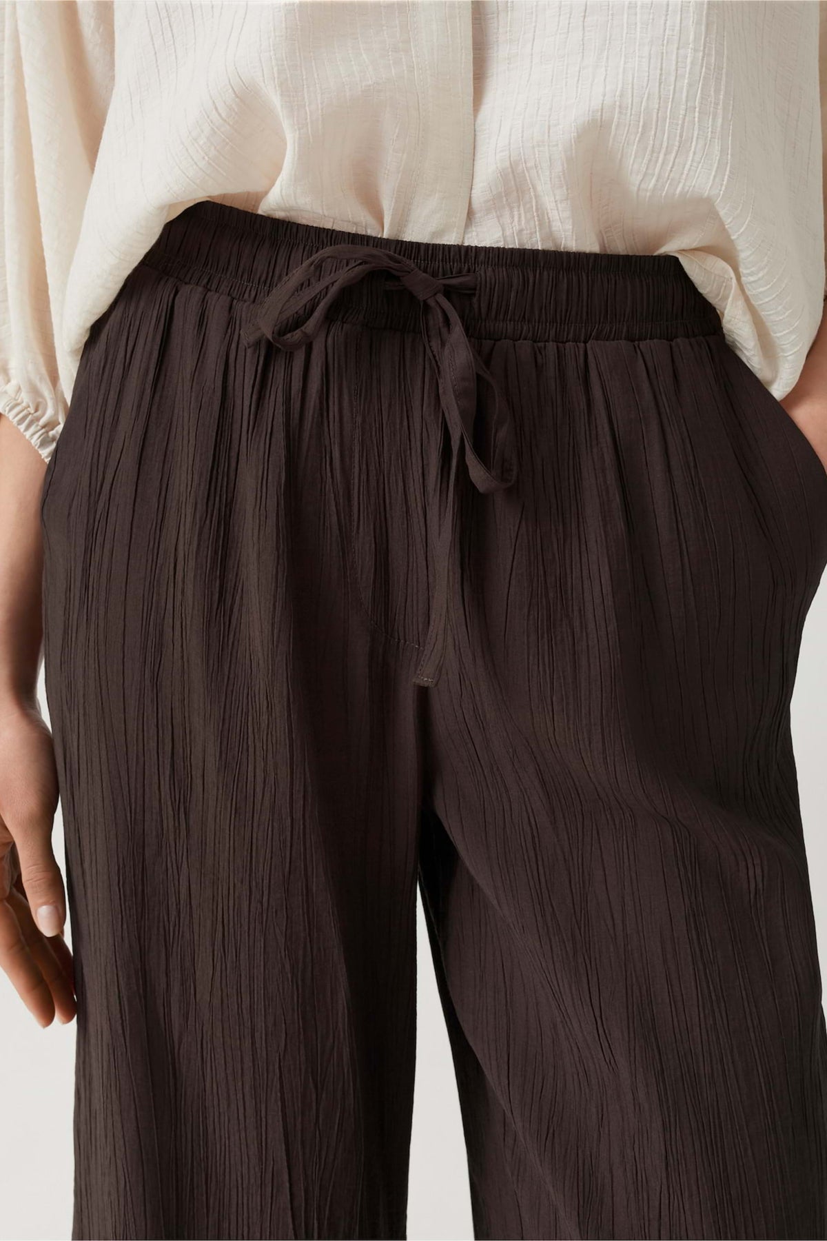Lichtbruine crinkled broek Marou Affogato van Opus, close-up van de textuur en pasvorm op model.