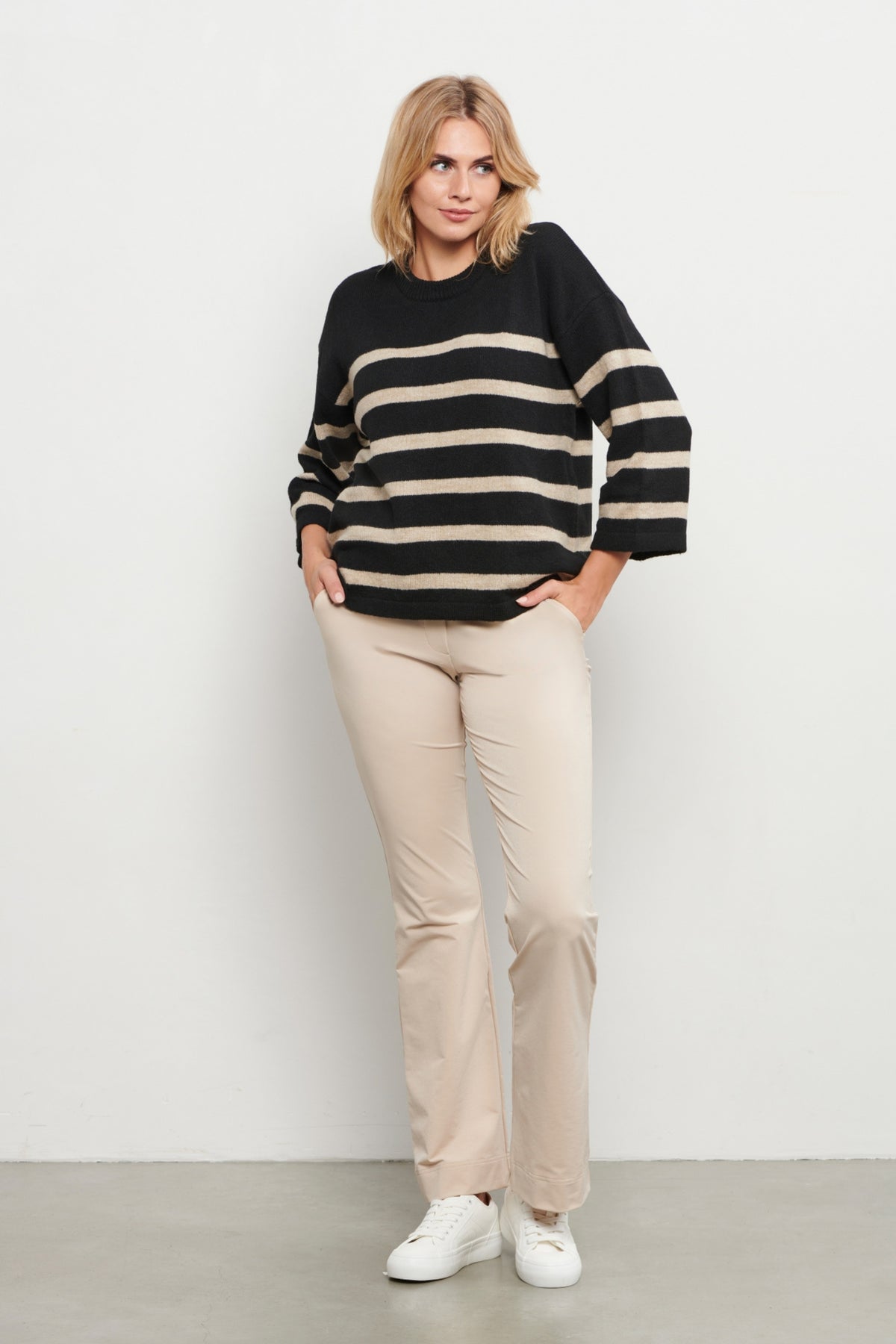 Lichtbruine travel broek Penelope Flare van &Co woman, met hoge taille en wijde pijpen, gelegen op een witte achtergrond.