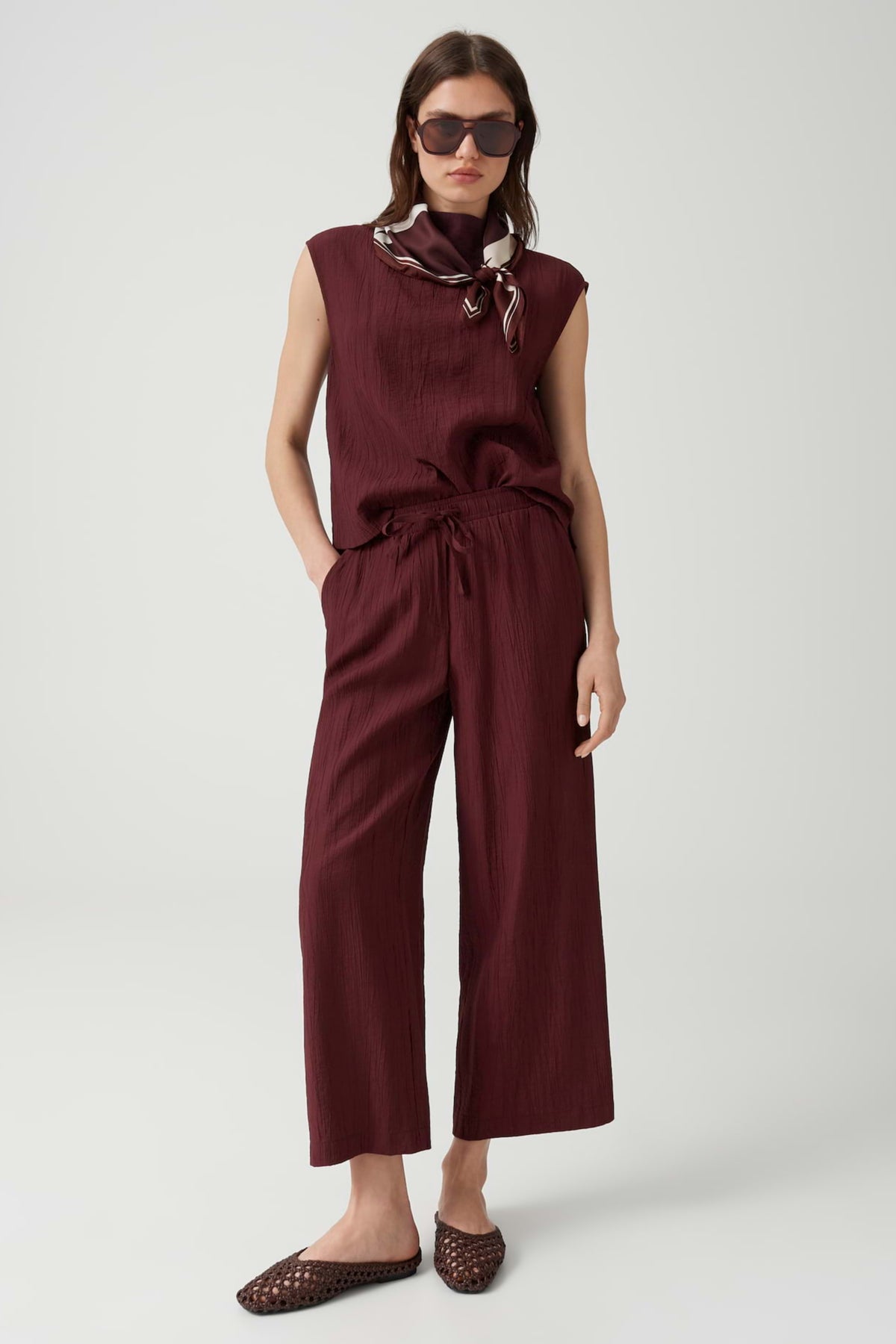 Opus Marou Crinkled Cherry Jam broek in crinkellook, donkerrode kleur en comfortabele pasvorm, zichtbaar in de afbeelding.