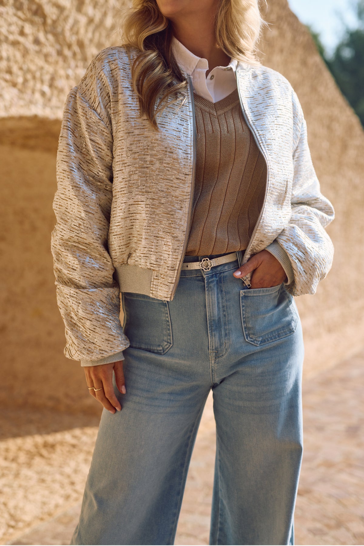 Nukus Babette Silver Camel jas met glanzende afwerking en capuchon, zichtbaar in de afbeelding, voor dames en wintergebruik.