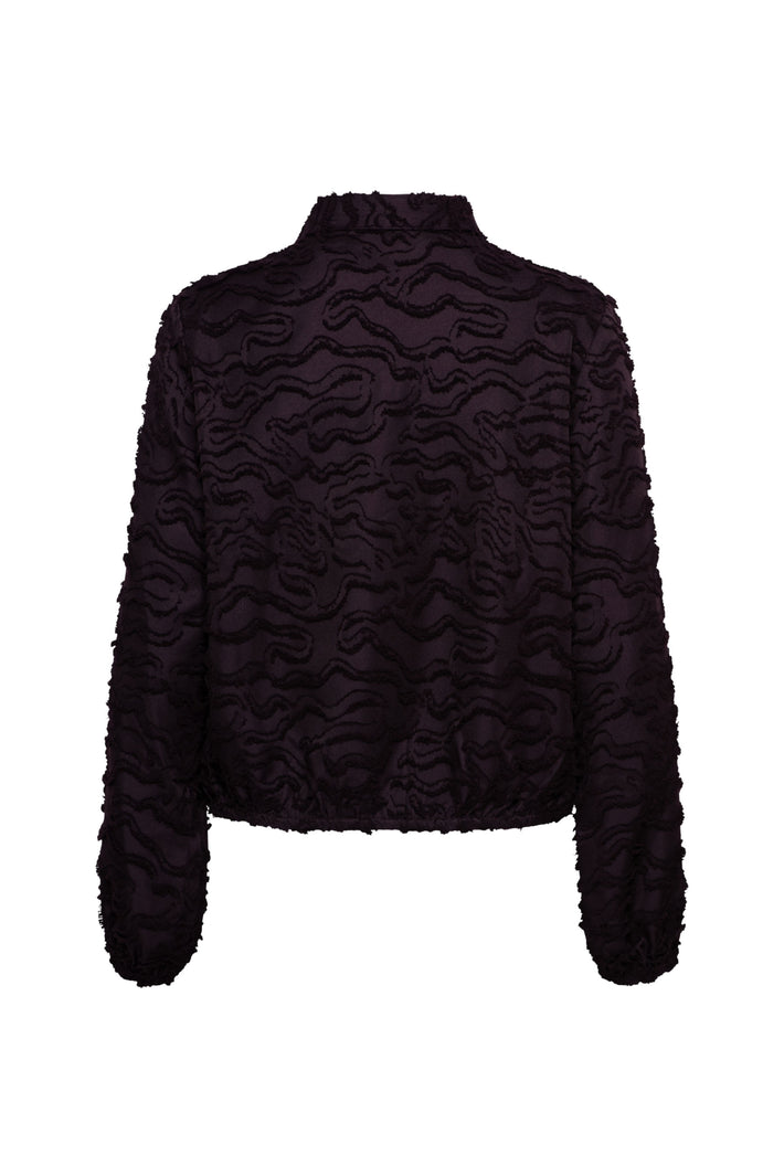 Donkere paarse blouse Wendelien van &Co woman, met elegante pasvorm en lange mouwen, hangend aan een kapstok.
