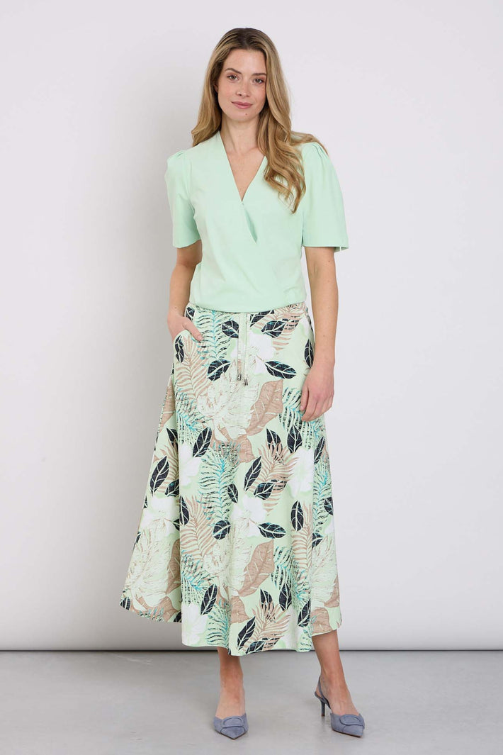 Luchtige reisrok van Mi Piace met botanisch print in pistachekleur, zachte stoffen en comfortabele pasvorm.