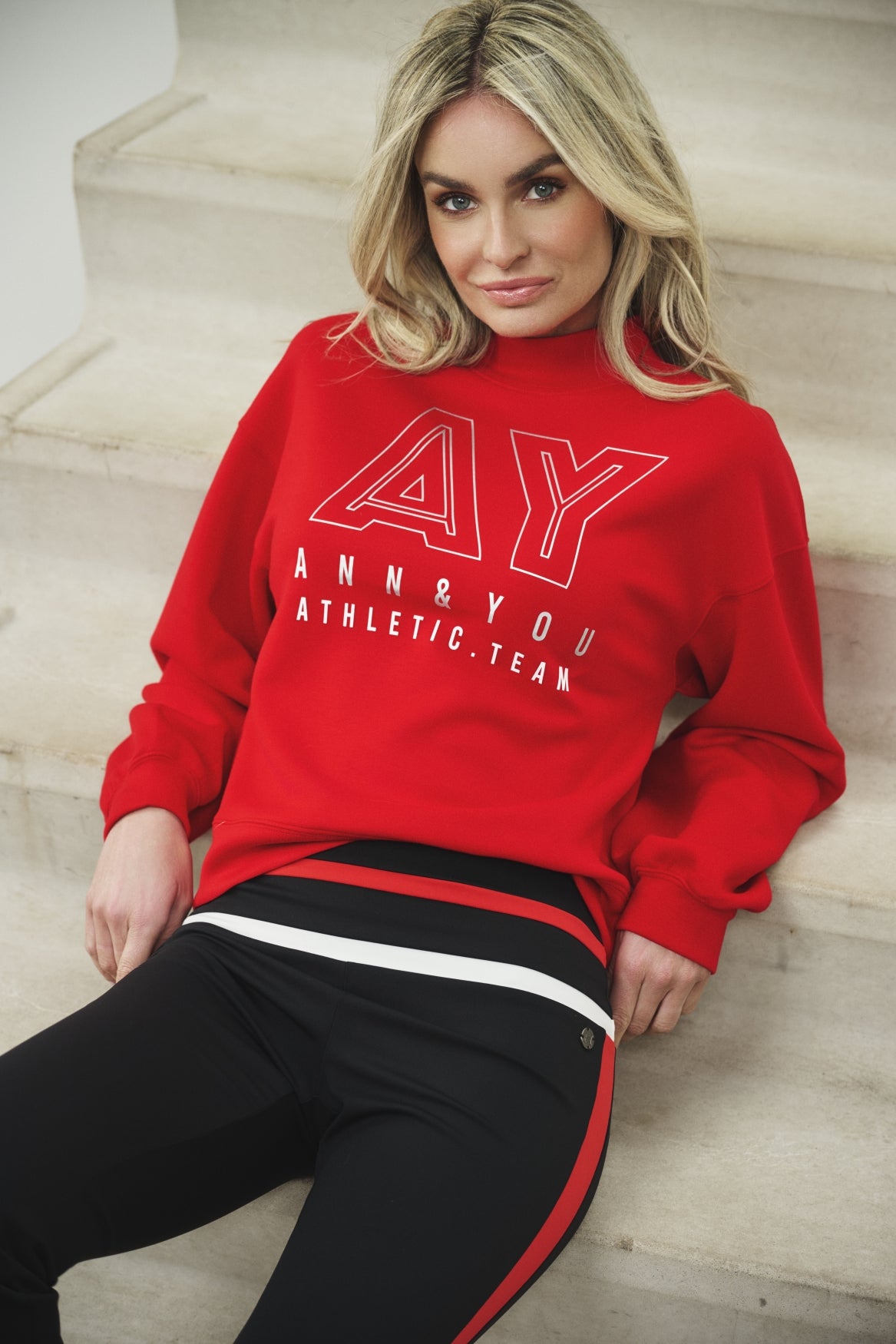 Rode Ann & You Sweater Blaire A26 met lange mouwen en ronde hals, gedragen door een persoon op een neutrale achtergrond.