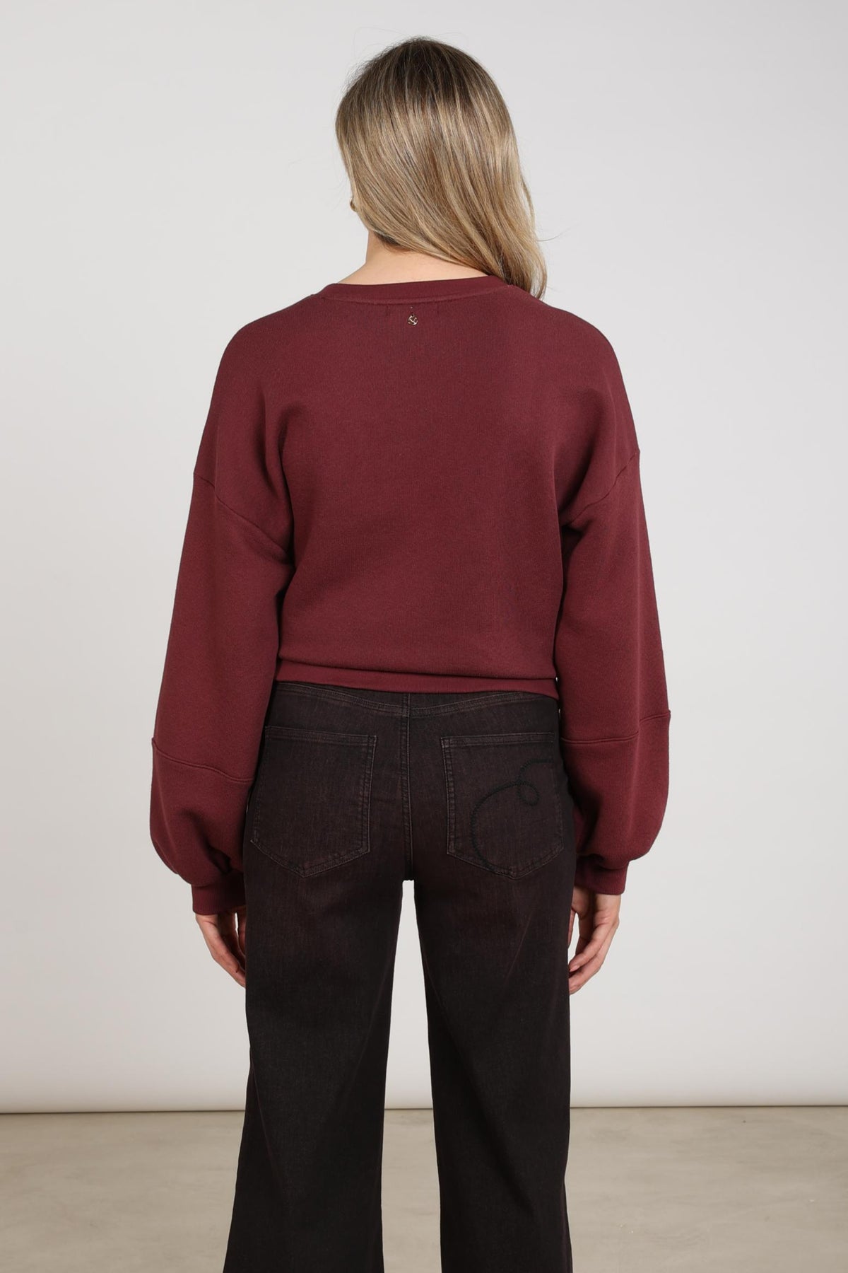 Nukus Trui Nicola Cherry in warm beige met zachte stof en ronde hals, zichtbaar op de afbeelding.