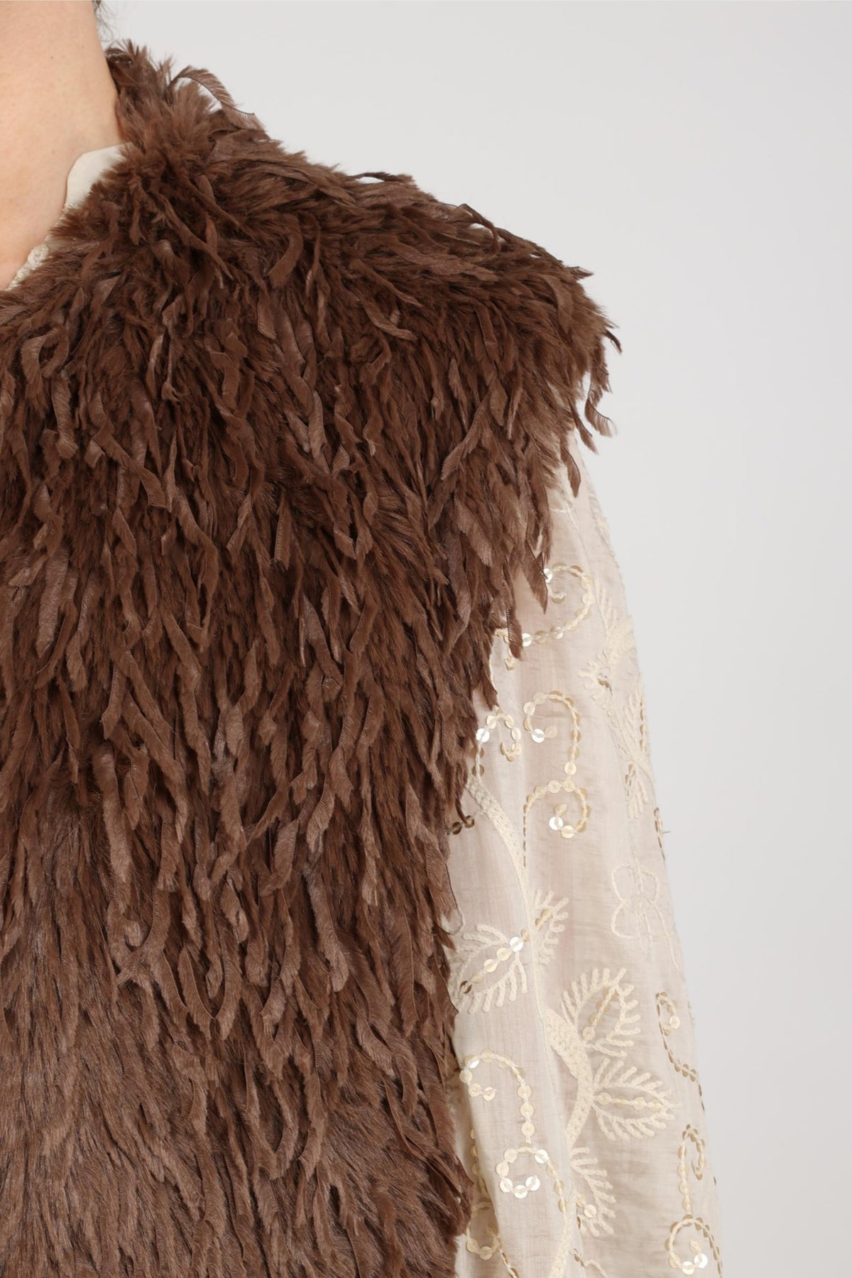Taupe Nukus Mila Feather gilet met dons en ritssluiting, zichtbaar op de afbeelding.