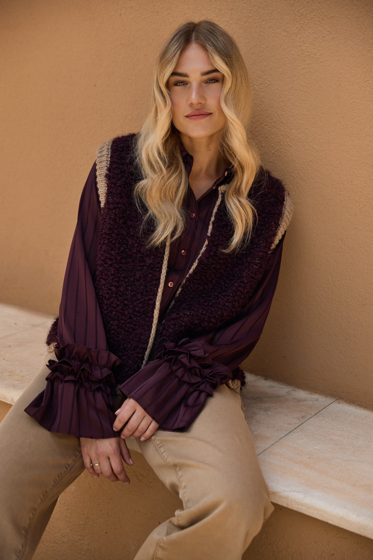 Taupe gekleed gilet van Nukus Lana Cherry met knopen en zachte stof, gedragen door een model op de afbeelding.