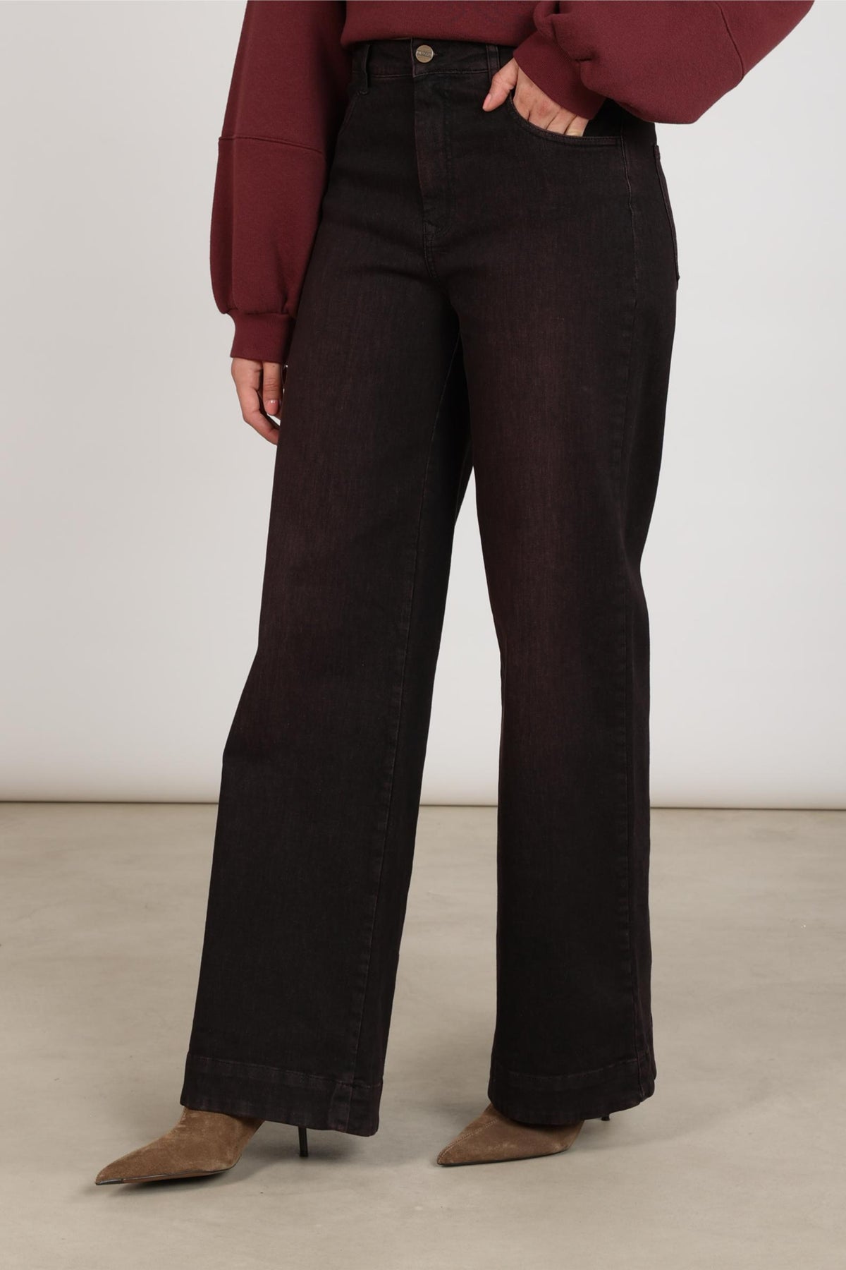 Donkerblauwe jeans Abby Cherry van Nukus, getoond op een model, met een klassieke pasvorm en opvallende stikdetails.