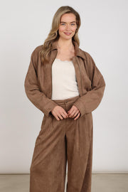 Taupe Nukus Daisey jas met zachte stof en ronde hals, gedragen door een model, geschikt voor casual en stijlvolle outfits.