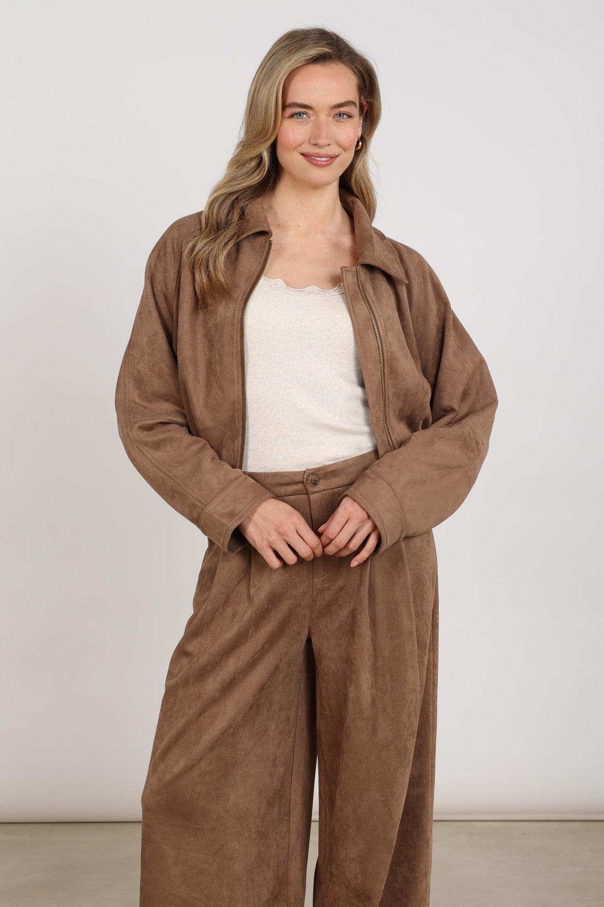 Taupe Nukus Daisey jas met zachte stof en ronde hals, gedragen door een model, geschikt voor casual en stijlvolle outfits.