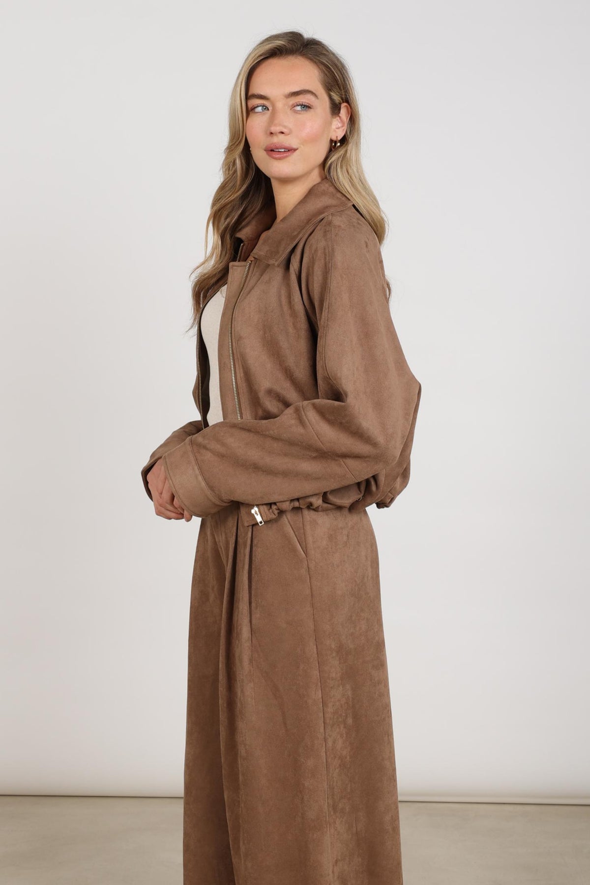 Taupe Nukus Daisey jas met capuchon en knopen, casual winterkleding voor dames, getoond op een model.