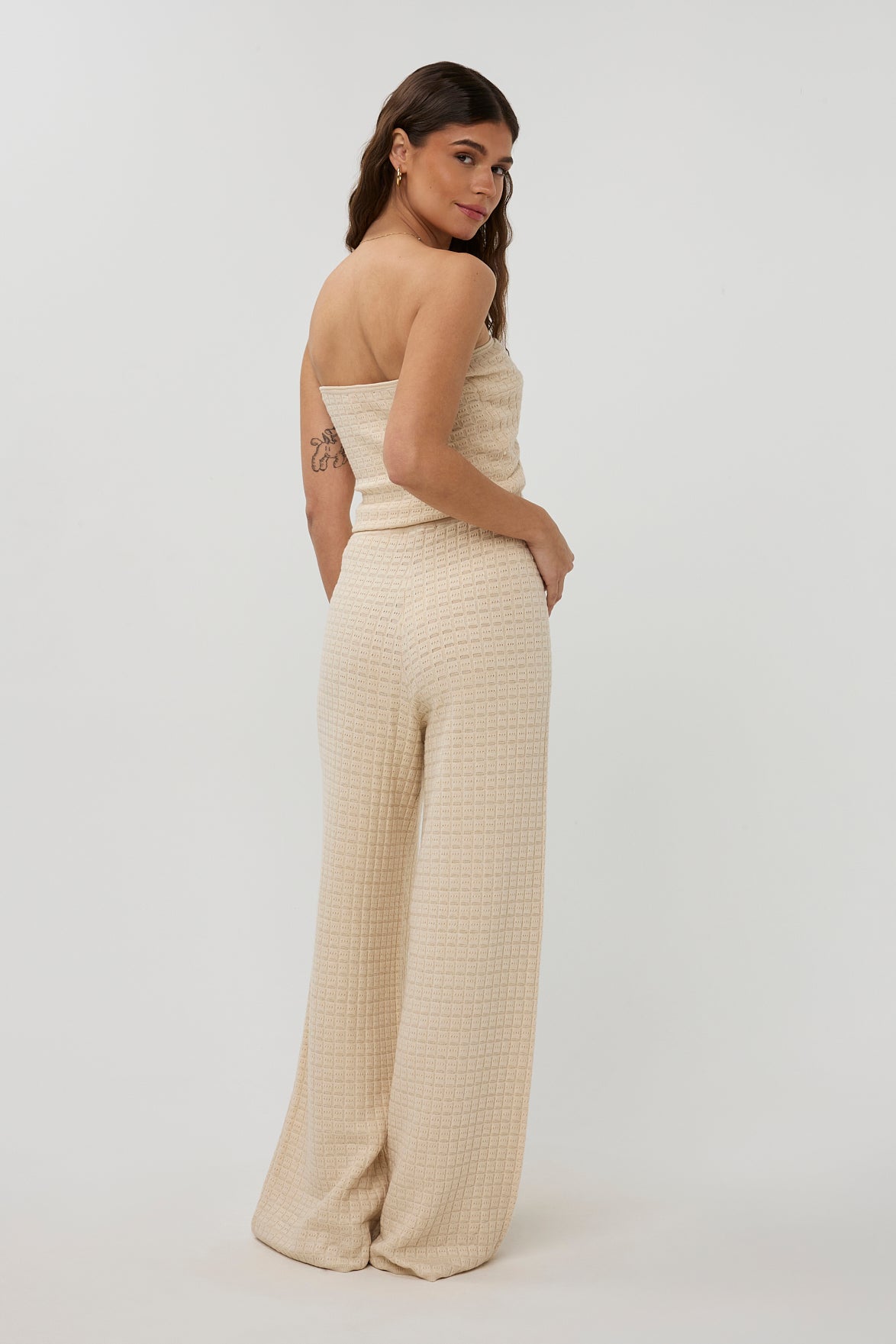 Beige broek van Studio Amaya met een relaxte pasvorm en zachte stof, gedragen door een model.