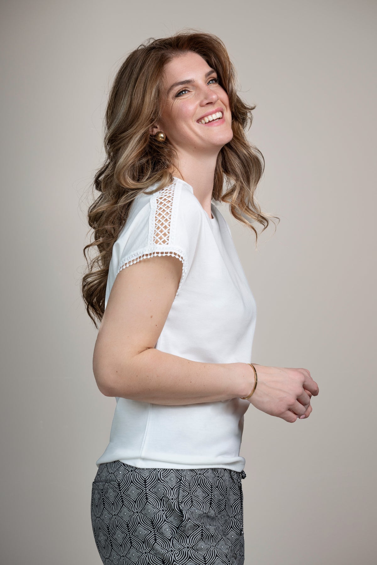 Offwhite top Lianne van Elvira Casuals met korte mouwen en ronde hals, gedragen door een model, close-up op de stof en pasvorm.