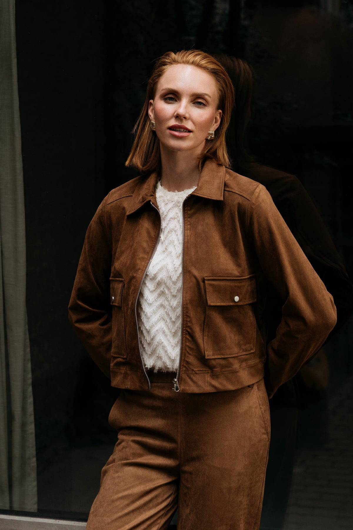 Damesjacke Hazel Caramel van &Co woman, lichte bruine jas met knopen en reverskraag, gedragen door een model.