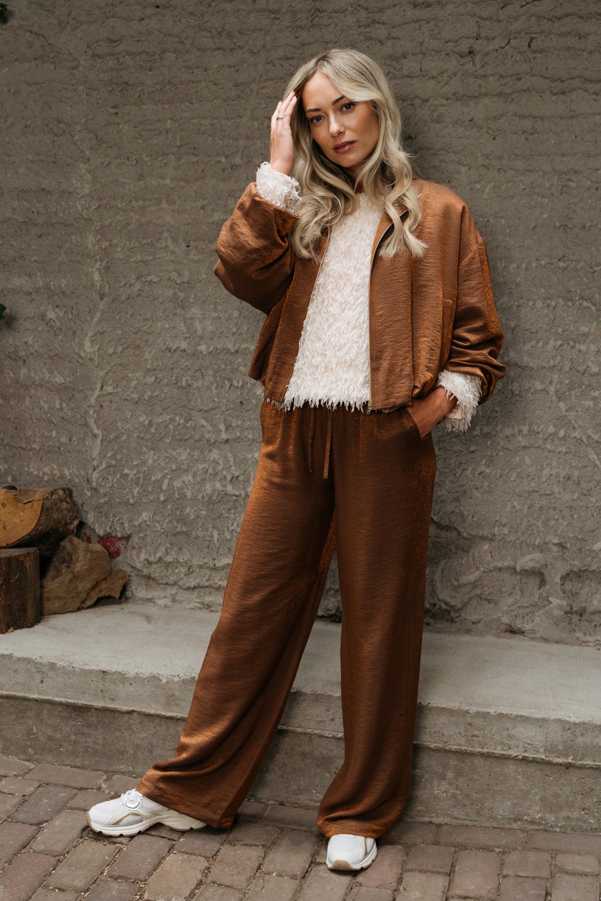 Lichte koperen jas voor dames van &Co woman, stijlvol en comfortabel, gedragen door een model met lange mouwen en knoopsluiting