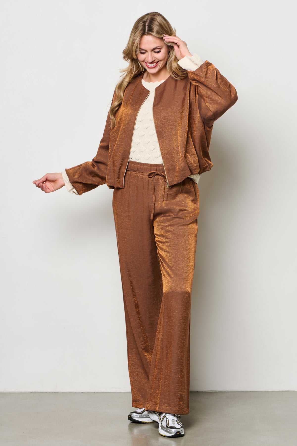 Zarina Copper JA138 jacket van &Co woman, close-up van de lichtbruine jas met details en knopen, gedragen door een model.