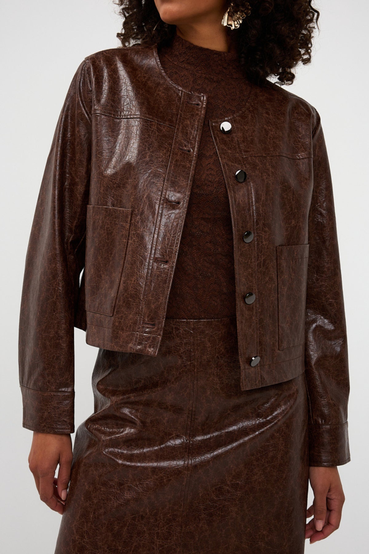 Lacquer jas in chocoladebruin van EsQualo, getailleerd model met opvallende afwerking en stijlvolle uitstraling.