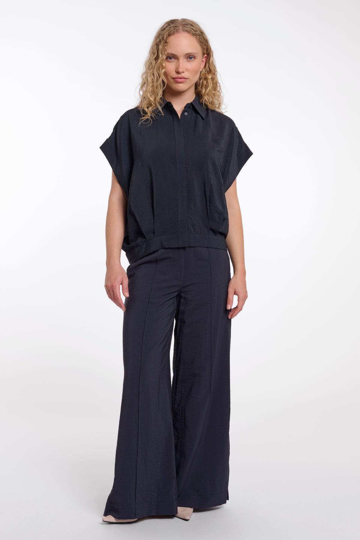 Donkerblauwe blouse Imela van Rino & Pelle met stijlvolle kraag en knoopsluiting, gedragen door een model.